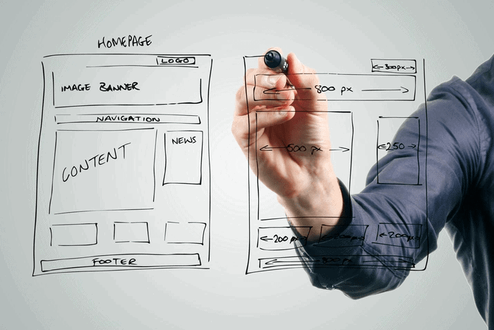a man working on the mockup of his website on a whiteboard